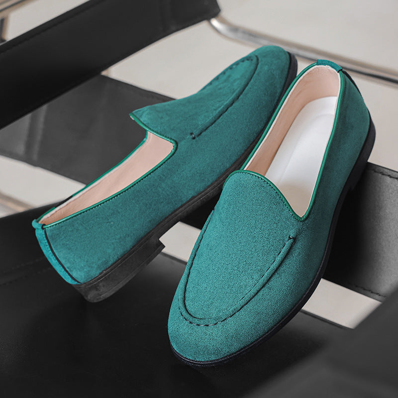 Teal loafers on a chair with a neutral background
