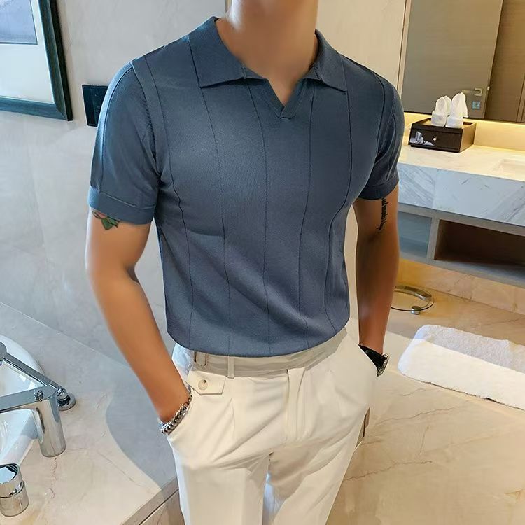 Person wearing a blue polo shirt and white pants in a bathroom setting